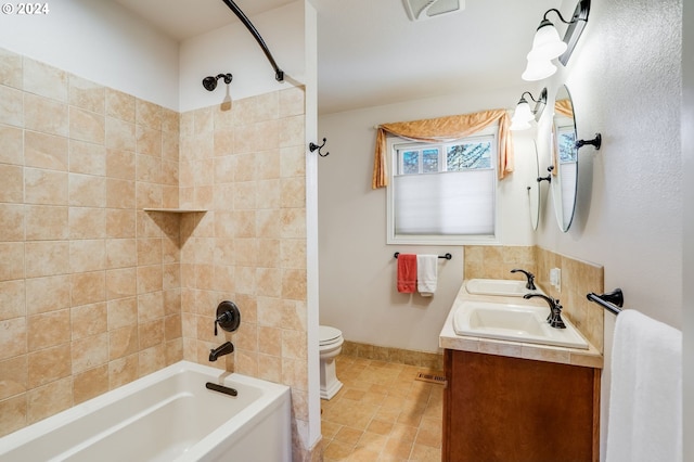 full bathroom with toilet, tiled shower / bath combo, and vanity