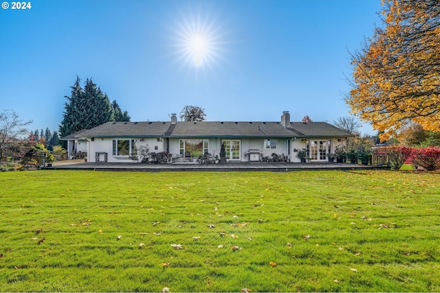 back of property with a lawn and a patio area