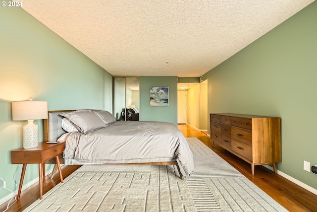 bedroom with wood-type flooring and a textured ceiling