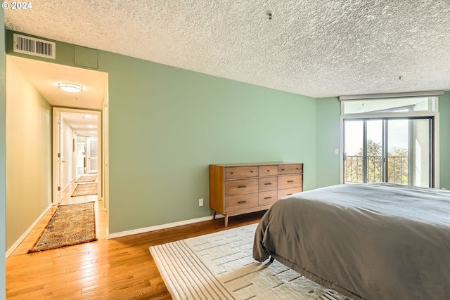 bedroom featuring light hardwood / wood-style flooring and a textured ceiling