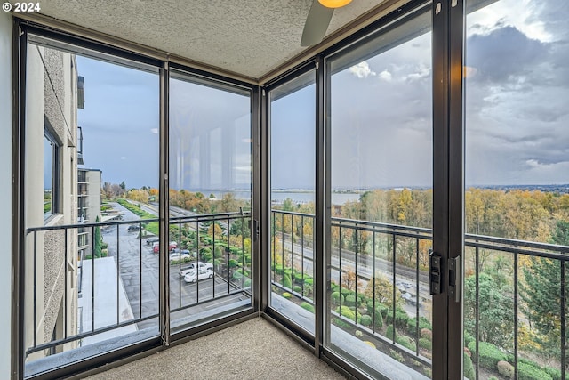 unfurnished sunroom featuring ceiling fan