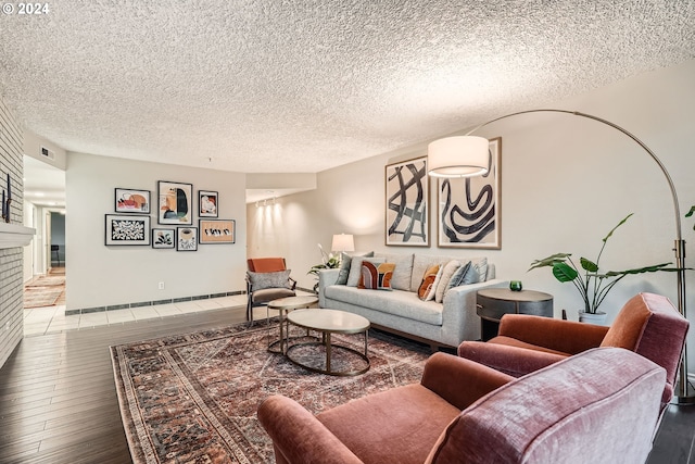 living room with hardwood / wood-style floors, a fireplace, and a textured ceiling