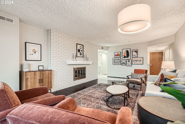 living room with a textured ceiling and a brick fireplace