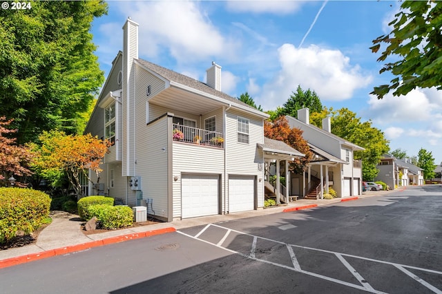 view of front of property with a garage, a residential view, and central AC unit