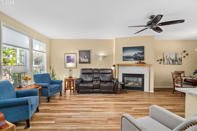 living room with a tiled fireplace, hardwood / wood-style floors, and ceiling fan