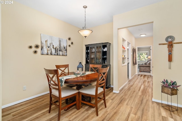 dining area featuring built in shelves and light hardwood / wood-style floors