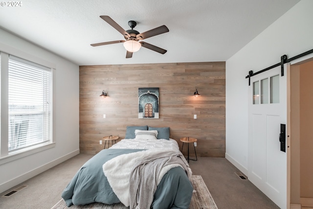 carpeted bedroom with wood walls and ceiling fan