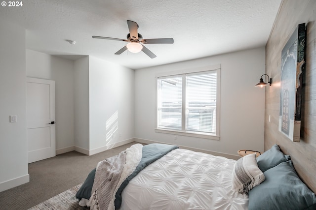 carpeted bedroom featuring ceiling fan and a textured ceiling