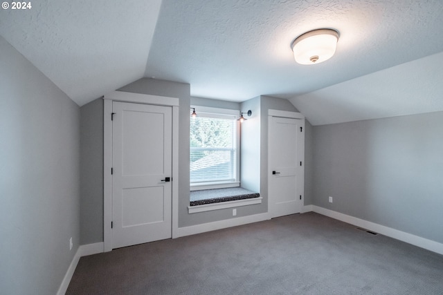 bonus room with a textured ceiling, carpet floors, and lofted ceiling