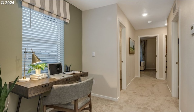 home office with visible vents, baseboards, and light carpet