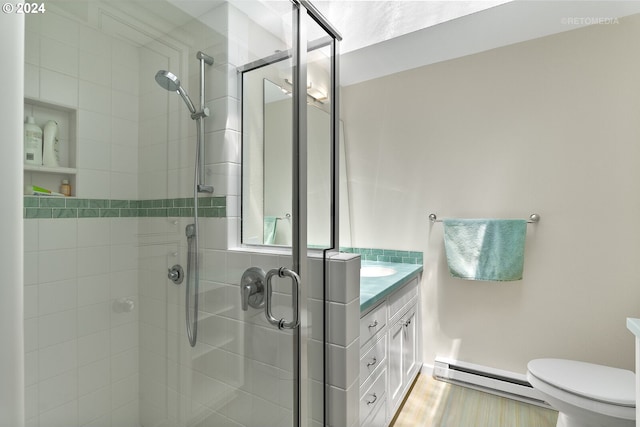 bathroom featuring vanity, toilet, a shower with door, and a baseboard radiator