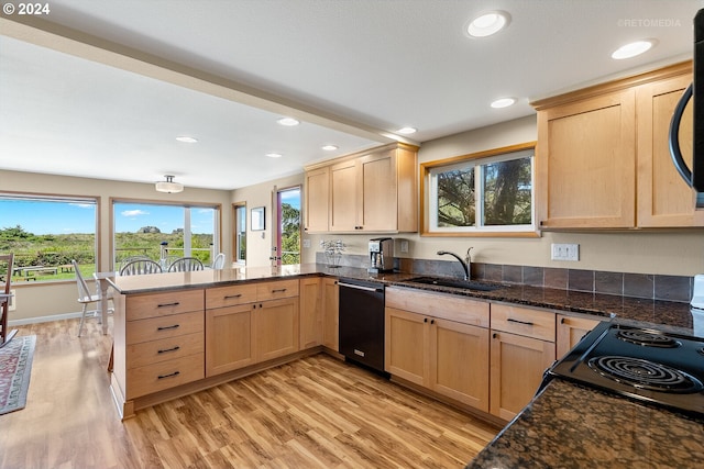 kitchen featuring black appliances, sink, dark stone countertops, light hardwood / wood-style floors, and kitchen peninsula