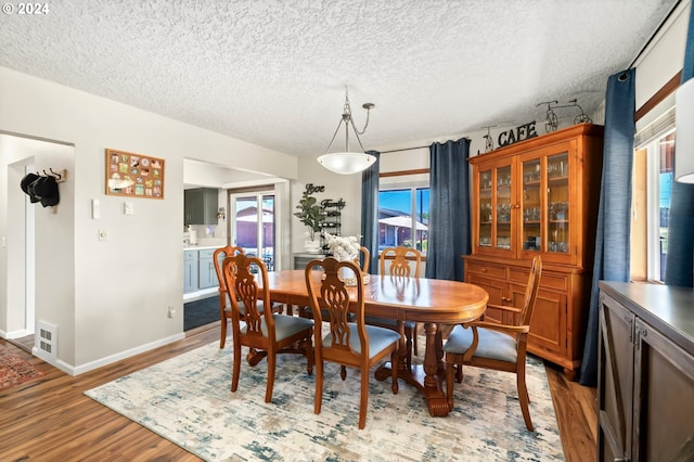 dining area featuring a textured ceiling and light hardwood / wood-style floors