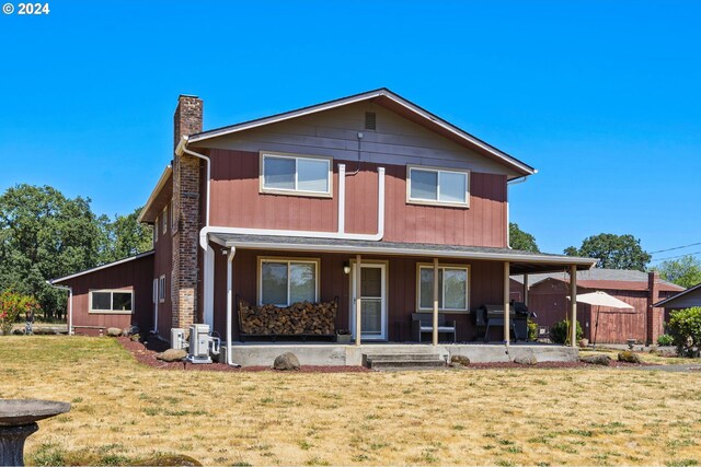 view of front of house featuring a porch, a chimney, and a front lawn