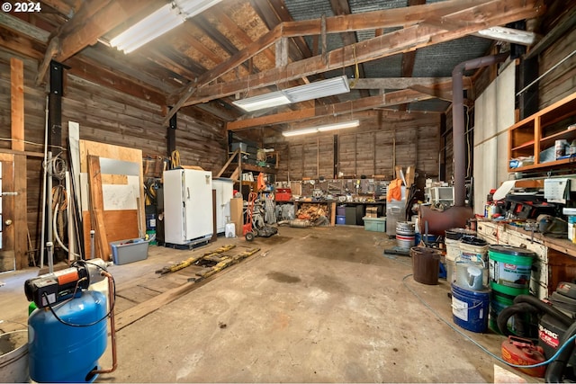 garage with a workshop area and freestanding refrigerator