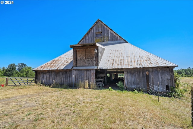 view of side of property featuring an outdoor structure, fence, and a barn