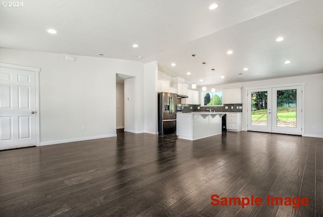 unfurnished living room featuring french doors, lofted ceiling, and dark wood-type flooring