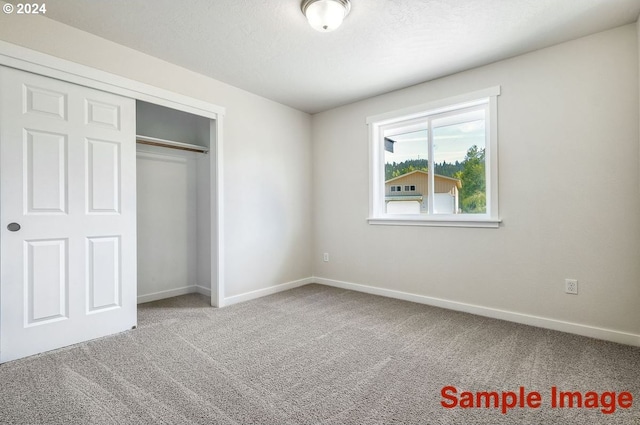 unfurnished bedroom with carpet flooring and a closet