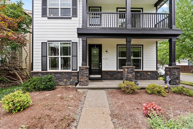 property entrance featuring a balcony and a porch