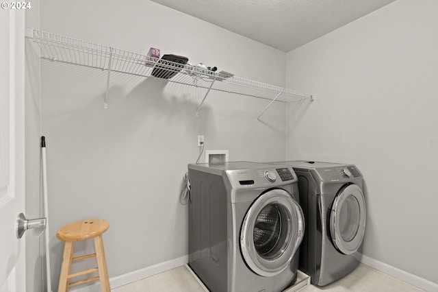 washroom featuring light tile patterned floors and washing machine and clothes dryer