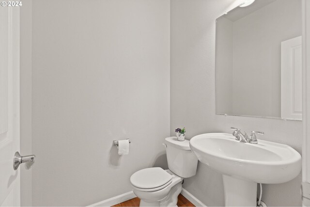 bathroom featuring toilet and wood-type flooring