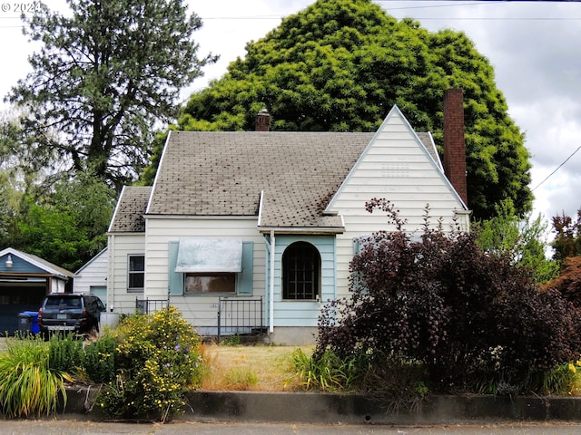 view of front facade featuring a garage and an outbuilding