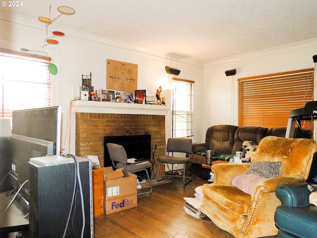 living room featuring crown molding, dark hardwood / wood-style floors, and a brick fireplace