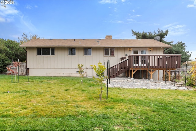 rear view of house with a wooden deck and a yard