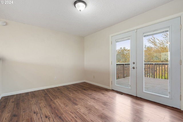 interior space featuring dark wood-type flooring, a textured ceiling, and french doors