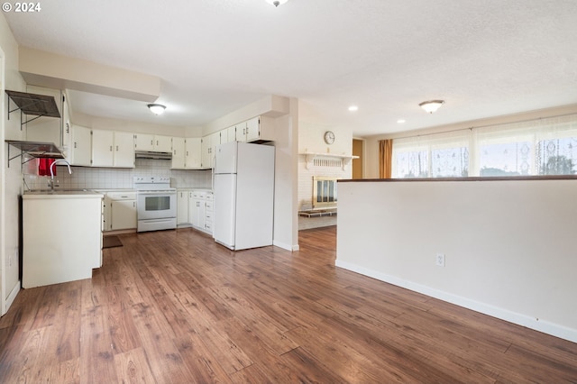 kitchen featuring dark wood-type flooring, backsplash, white cabinets, and white appliances