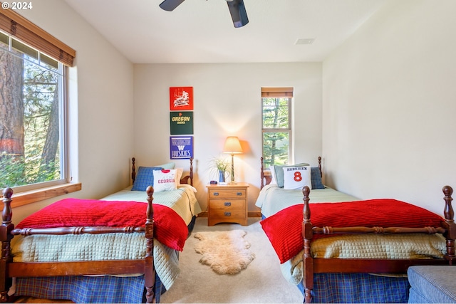 bedroom featuring ceiling fan, carpet, and multiple windows