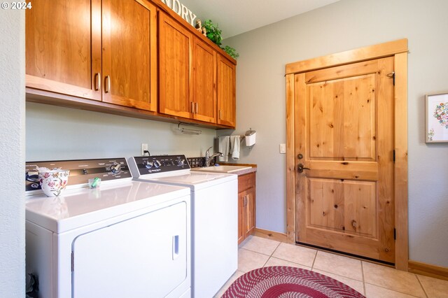 laundry room with cabinets, separate washer and dryer, sink, and light tile patterned floors