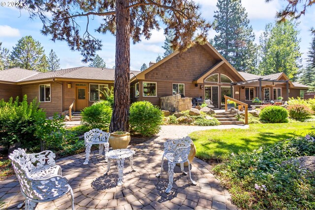 rear view of house featuring a yard and a patio area