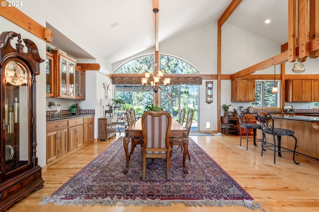 dining space featuring beamed ceiling, high vaulted ceiling, a chandelier, and light wood-type flooring