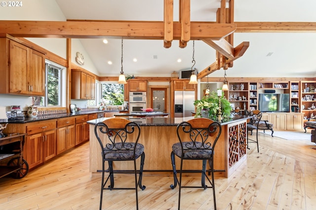 kitchen with stainless steel appliances, a center island, pendant lighting, and a kitchen bar