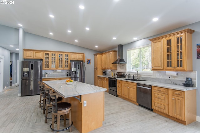 kitchen with wall chimney exhaust hood, stainless steel appliances, sink, a center island, and vaulted ceiling