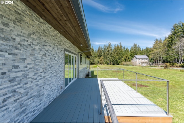 wooden deck featuring a lawn