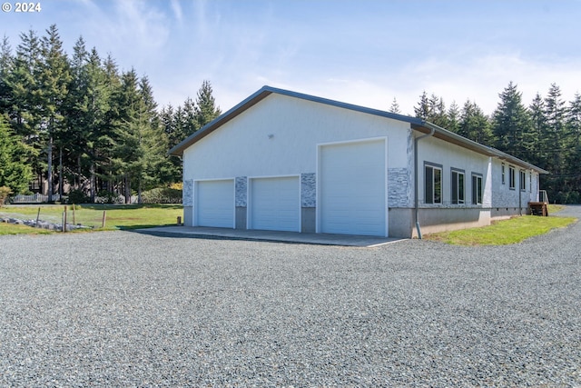 view of side of home featuring an outbuilding, a garage, and a lawn