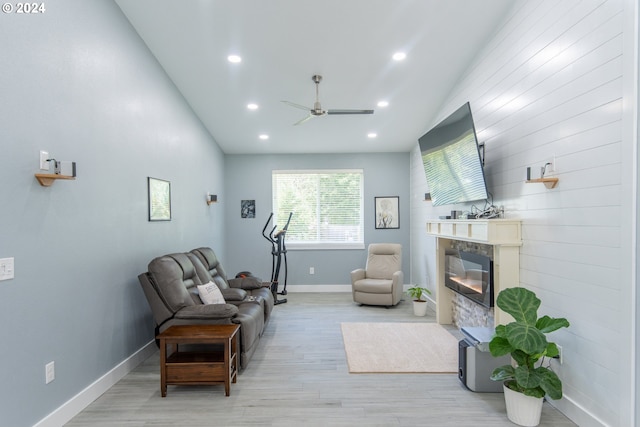 living area with ceiling fan, light wood-type flooring, and vaulted ceiling