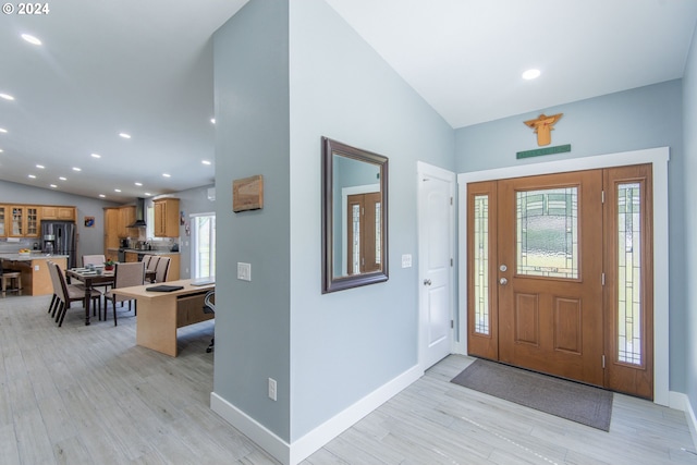 entryway with vaulted ceiling and light wood-type flooring