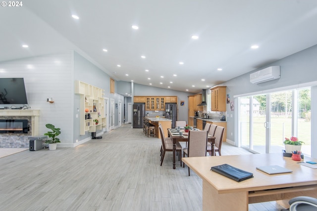 dining area featuring light hardwood / wood-style flooring, an AC wall unit, and lofted ceiling