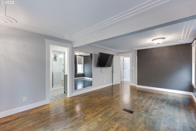 unfurnished room with dark wood-type flooring, a textured ceiling, and ornamental molding