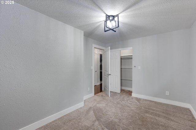 unfurnished bedroom with carpet flooring, a textured ceiling, and a closet