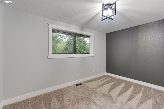 spare room with carpet flooring and a textured ceiling