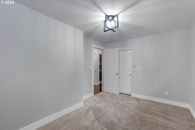 spare room featuring carpet floors and a textured ceiling