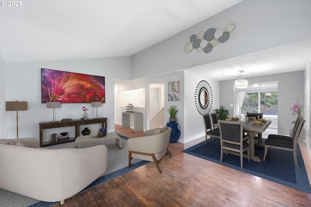 living room featuring a notable chandelier, vaulted ceiling, and hardwood / wood-style flooring