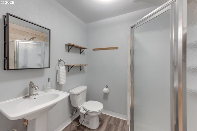 bathroom with sink, wood-type flooring, an enclosed shower, and toilet