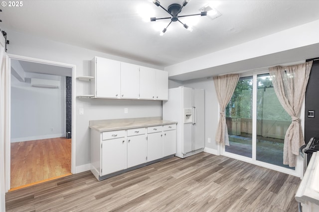 kitchen with white refrigerator with ice dispenser, light hardwood / wood-style floors, white cabinetry, and a wall mounted AC