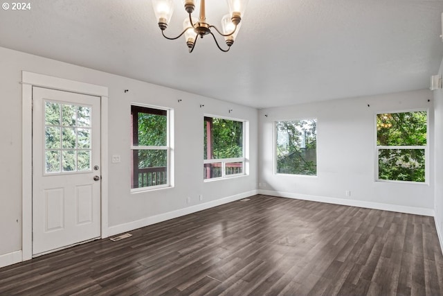 entryway featuring a notable chandelier, a wealth of natural light, and dark hardwood / wood-style floors