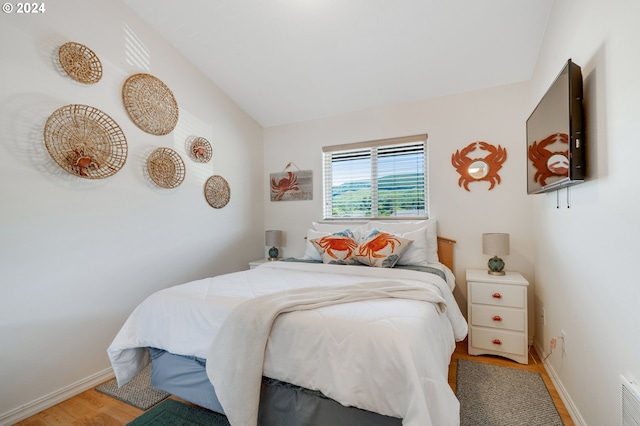 bedroom with hardwood / wood-style floors and vaulted ceiling